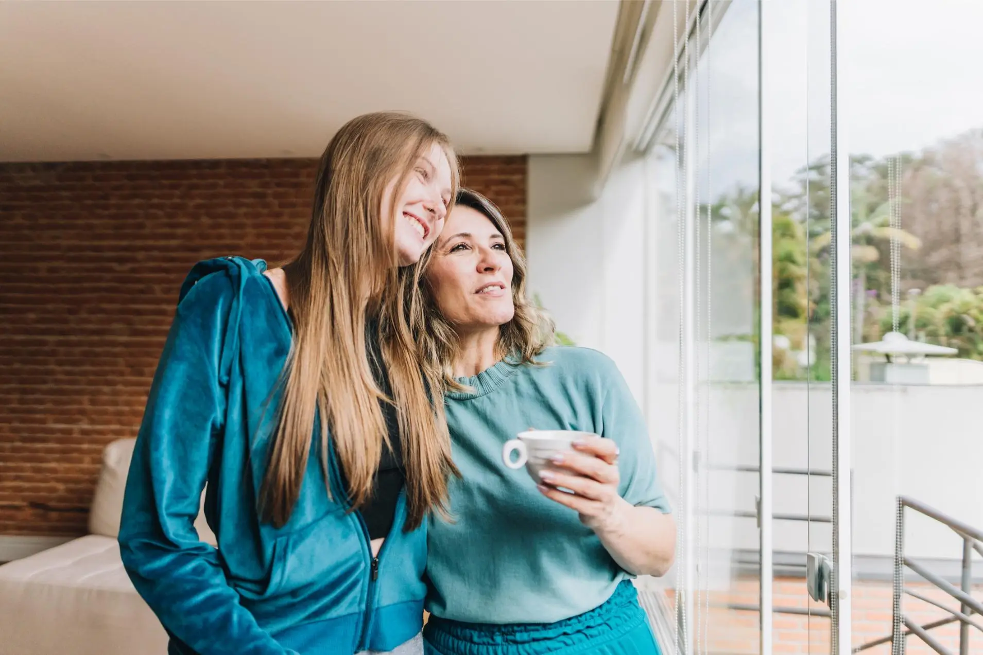 Happy mother and daughter embracing at home