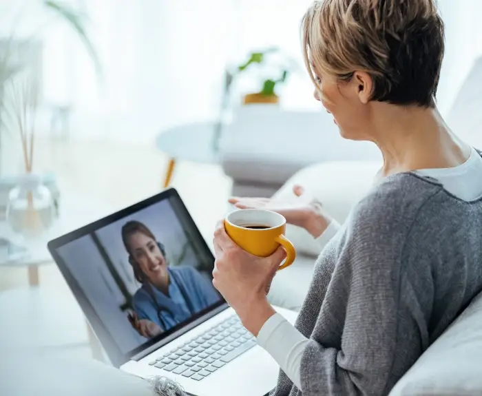 woman-on-couch-with-coffee-in-a-video-session-with-therapist-dispelling-myths-about-online-therapy