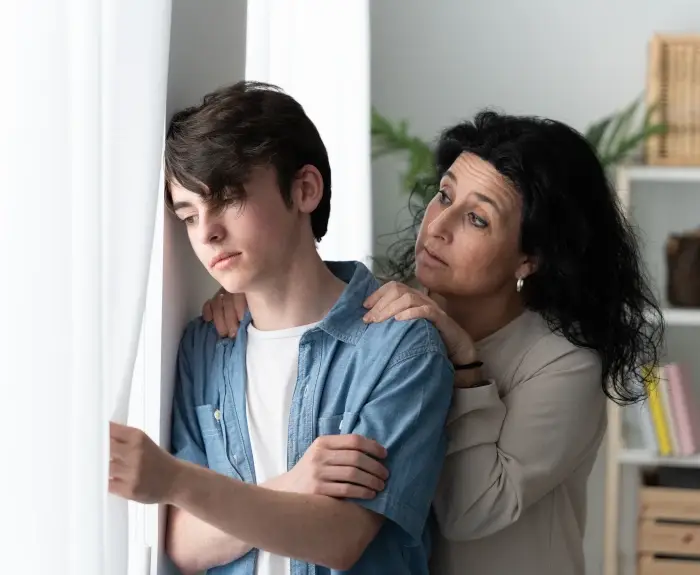 mom-worried-about-teen-son-staring-out-the-window-dealing-with-his-anxiety