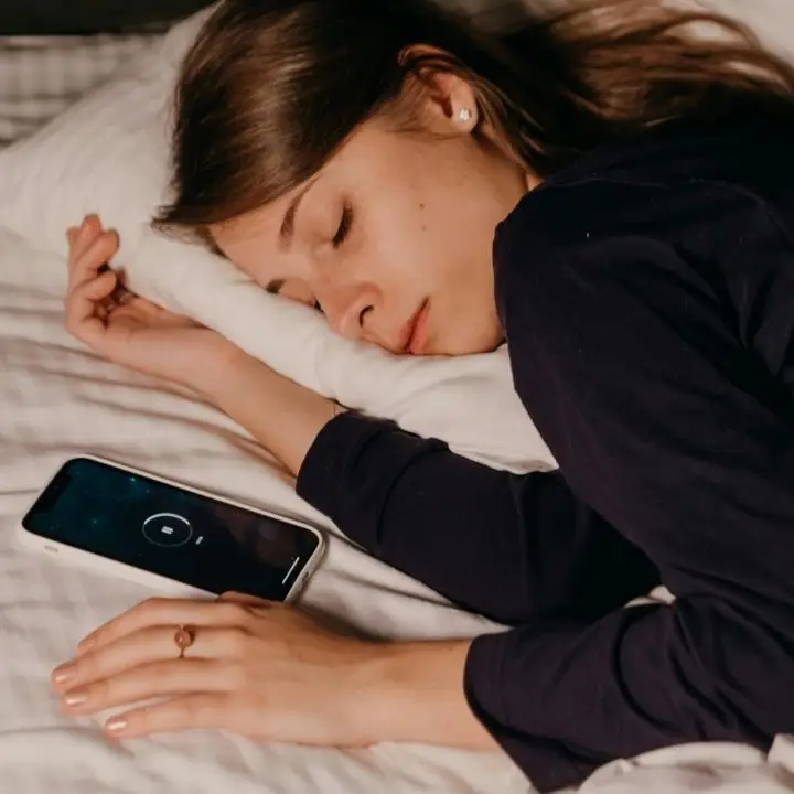 Woman sleeping beside phone.