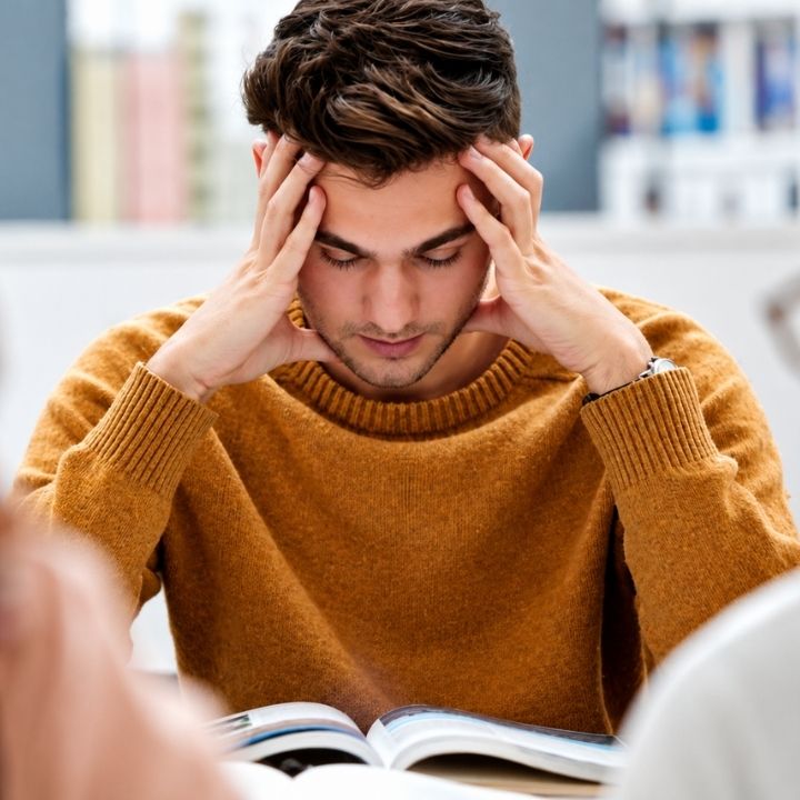 College student experiencing academic stress and anxiety while studying for exams.