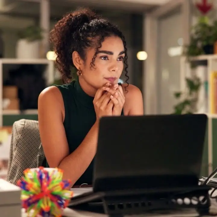 Woman concentrating at laptop while managing attention and focus challenges.