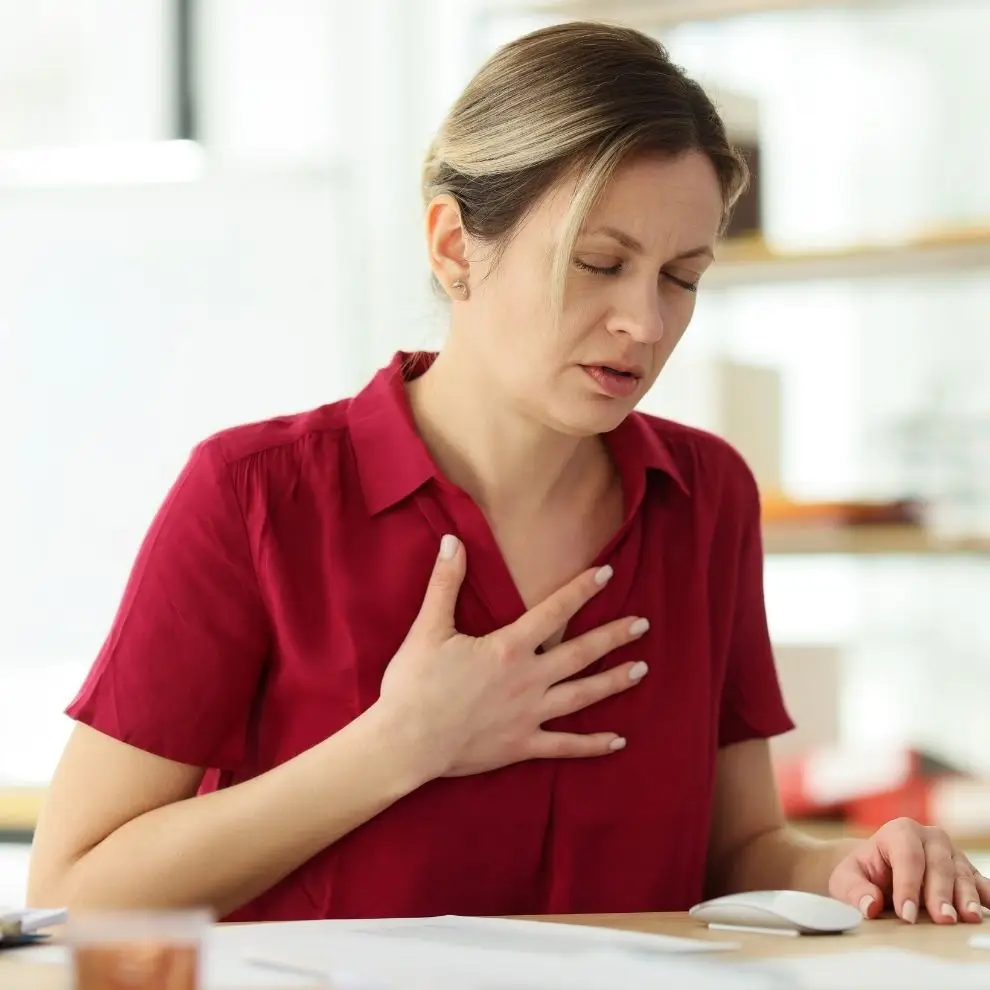 Woman experiencing chest tightness and shortness of breath during an anxiety attack.